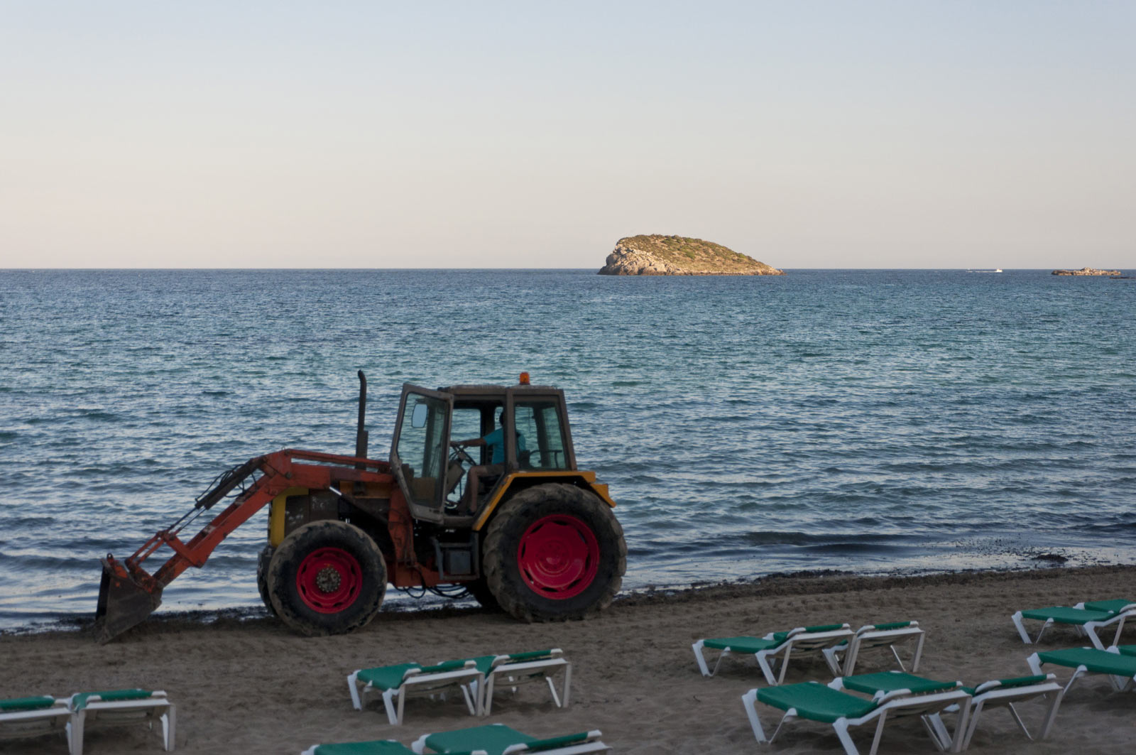 Трактор убирает пляж Кала Нова на Ибице